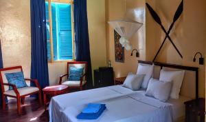 格雷岛La Maison du Marin的卧室配有白色的床和2把椅子