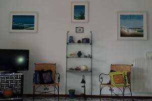 伊斯基亚Giardino Mediterraneo的客厅配有2把椅子和平面电视
