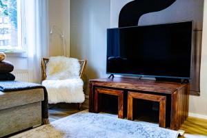 库奥皮奥Mukava saunallinen kaksio omalla sisäänkäynnillä ja ilmaisella autopaikalla的客厅配有木桌上的平面电视