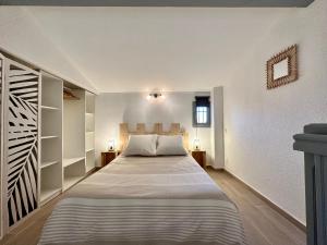 圣马迪拉莫Appartement Duplex 4pers Climatisé - Location Valadié Camargue的卧室配有一张带白色墙壁的大床