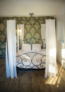阿维尼翁Mas de la Roule, 4 studios, piscine chauffée, studio SPA, parc 2 ha, Pont d'Avignon à pied的一间卧室配有一张带华丽床头板和窗帘的床