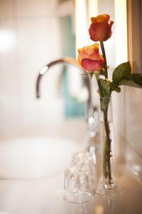 埃门丁根马克格拉夫商务艺术旅馆的一张桌子上玫瑰花的花瓶