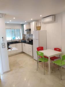 西迪·布·赛义德Cosy Appartement in "Sidi Bou Said"的厨房配有桌子和绿色椅子