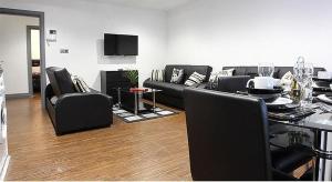曼彻斯特Apartment in the Heart of the Northern Quarter的客厅配有黑色家具和桌子
