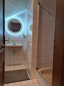 策尔廷根-拉蒂希Pension Birgit Pazen的一间带水槽、浴缸和镜子的浴室