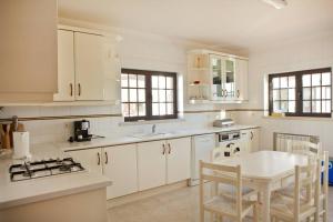 Spacious and family friendly villa at Lisbon coast的厨房配有白色橱柜和桌椅