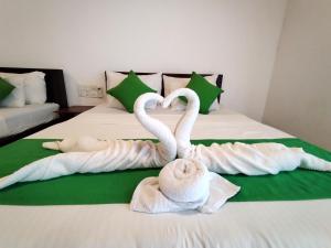 蒂瑟默哈拉默Village Mango Resort Yala的两个天鹅坐在床上