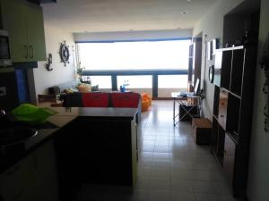 拉瓜伊拉Acogedor apartamento con piscina - Bleu Marine Suites的厨房以及带沙发的起居室。