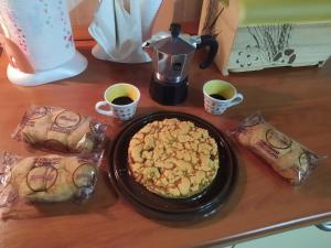 Casole BruzioAntico Borgo的一张桌子,上面放着一盘食物和两杯咖啡