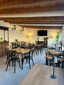 圣胡安德里奥Hotel Boutique Rincón de Luna的餐厅设有木桌、椅子和平面电视。