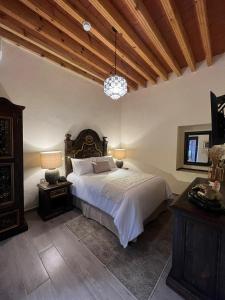 圣胡安德里奥Hotel Boutique Rincón de Luna的一间卧室设有一张大床和木制天花板