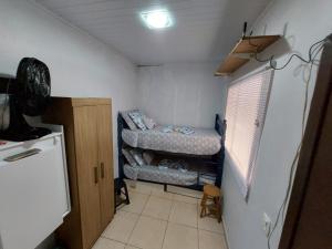 伊瓜苏Quarto Deluxe em Foz piscina wifi estacionamento cozinha E AR的小房间设有两张床和一台冰箱