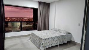 大坎普Estúdio no 27º Andar com Vista p/ Av. Afonso Pena的一间卧室设有一张床和一个大窗户