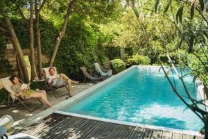 阿维尼翁巴拉卡涅花园住宿加早餐旅馆的两个女人坐在游泳池旁的椅子上