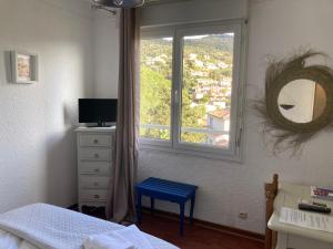 博尔马斯·莱斯·米默萨斯帕拉迪斯酒店的一间卧室设有窗户和一张带蓝色凳子的床