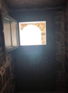 VolissosLemon's Cottage House, Volissos, Chios的黑暗房间中一扇带窗户的门