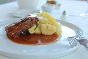巴拉斯港卡萨维尔纳精品酒店的桌上有肉和土豆的盘子