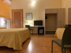 马萨阿农齐亚塔酒店的酒店客房设有两张床和一张书桌及电视
