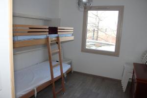 昂塞勒ANCELLE TAILLAS RDC CHALET的客房设有双层床和窗户。