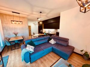 吉日茨科Apartament Morsa w Nautica Resort的客厅配有蓝色的沙发和桌子