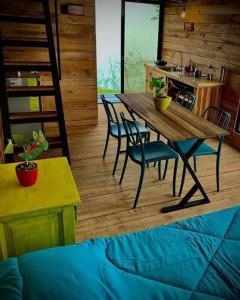 Alto Luciérnaga的带厨房的客房内的一张木桌和椅子