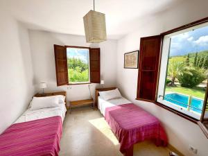 孔塞利Son Jordi nou, beautiful villa near Alaro big swimming pool, BBQ mountain views 12people的带窗户的客房内的两张床