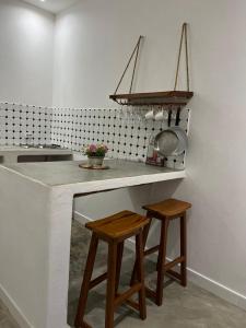 托弗海滩Casa Bali Tofo的厨房配有带水槽和2张凳子的台面