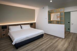 特拉诺瓦-布拉乔利尼Moody smart & comfy Hotel的卧室配有一张白色的大床,铺有木地板