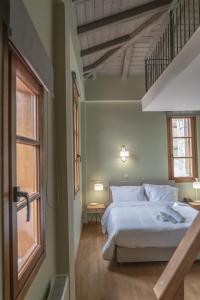 维蒂纳Anastasia's Suites Arcadia的卧室配有白色的床和窗户。