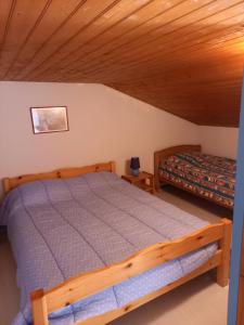 莱马特Talaris La Palmyre的一间卧室设有一张床和木制天花板