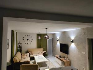 巴尔BONACA - BAR的客厅配有沙发和墙上的时钟