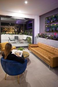 特拉诺瓦-布拉乔利尼Moody smart & comfy Hotel的坐在客厅的蓝色椅子上的女人