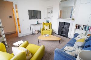 考斯Paskins, Cowes - Sleeps 4 - 2 Bed - 2 Bath - Central Location的客厅配有蓝色的沙发和黄色的椅子