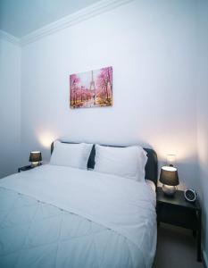 沃洛斯Angie's House Volos的卧室配有白色的床和墙上的绘画作品