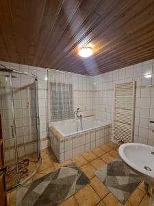塞埃巴克Ferienhaus Auszeit的带浴缸和盥洗盆的浴室