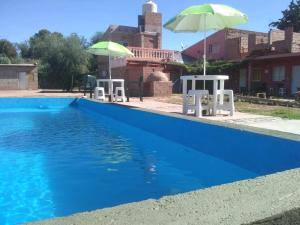 乌尼翁镇HOTEL FINCA AMANCAY的蓝色游泳池,配有两把遮阳伞和两把椅子