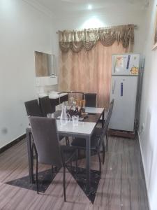 库马西BENJI'S VILLA的餐桌、椅子和冰箱