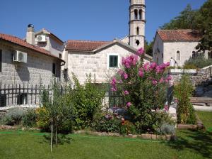 帕里斯特Guest House Dragutinovic的教堂前花园,教堂前方有塔楼