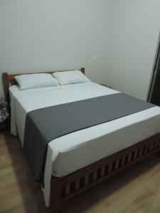 库尼亚Pousada Vale do Parque的一张配有白色床单和枕头的大床
