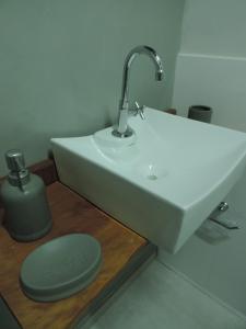 库尼亚Pousada Vale do Parque的浴室设有白色水槽和绿色蜡烛