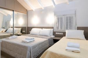 波利克罗诺Villa Pearl的一间设有两张床铺和毛巾的房间