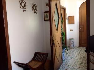 卡普里瓦伦蒂诺之家公寓的走廊上设有木门和椅子