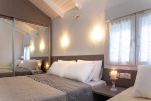 波利克罗诺Villa Pearl的一间卧室配有两张带白色枕头的床和窗户。