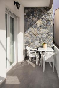 波利克罗诺Villa Pearl的一个带石墙的庭院里的桌椅