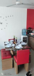 弗兰德斯Casa Veraneo Flandes con Piscina Privada的厨房里一张桌子,上面摆放着盘子和红色椅子