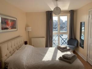 佩文西Fabulously located Marina apartment - marina views的卧室配有床、椅子和窗户。