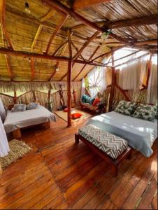 GiganteVilla Sonia Eco-Hostel的一间卧室设有两张床,铺有木地板