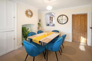 赛伦塞斯特Spacious home with garden Heart of the town WiFi Smart TV的一间带桌子和蓝色椅子的用餐室