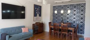 但尼丁St David's on James Luxury apartments的客厅配有蓝色的沙发、桌子和椅子