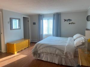 维勒蒙特玫瑰小屋住宿加早餐酒店的一间卧室配有一张床、一张桌子和一个窗户。